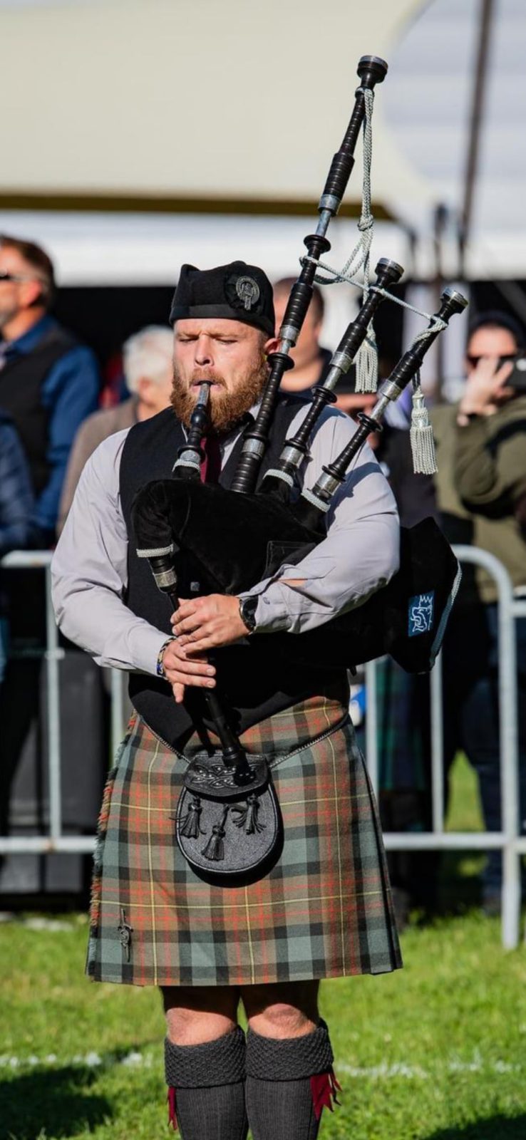 Bagpiper Bruce speelt solo doedelzak tijdens een wedstrijd in kilt en Glengarry
